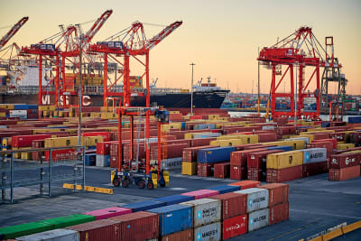 A shipping port with lots of cargo and cranes
